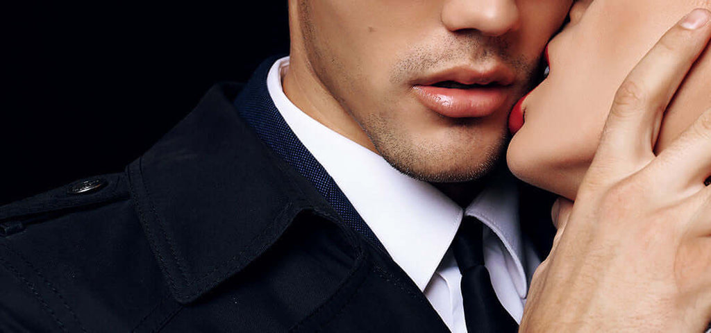Close-up of a couple in an intimate moment with a woman kissing a man’s cheek, highlighting sensual connection and intimacy.