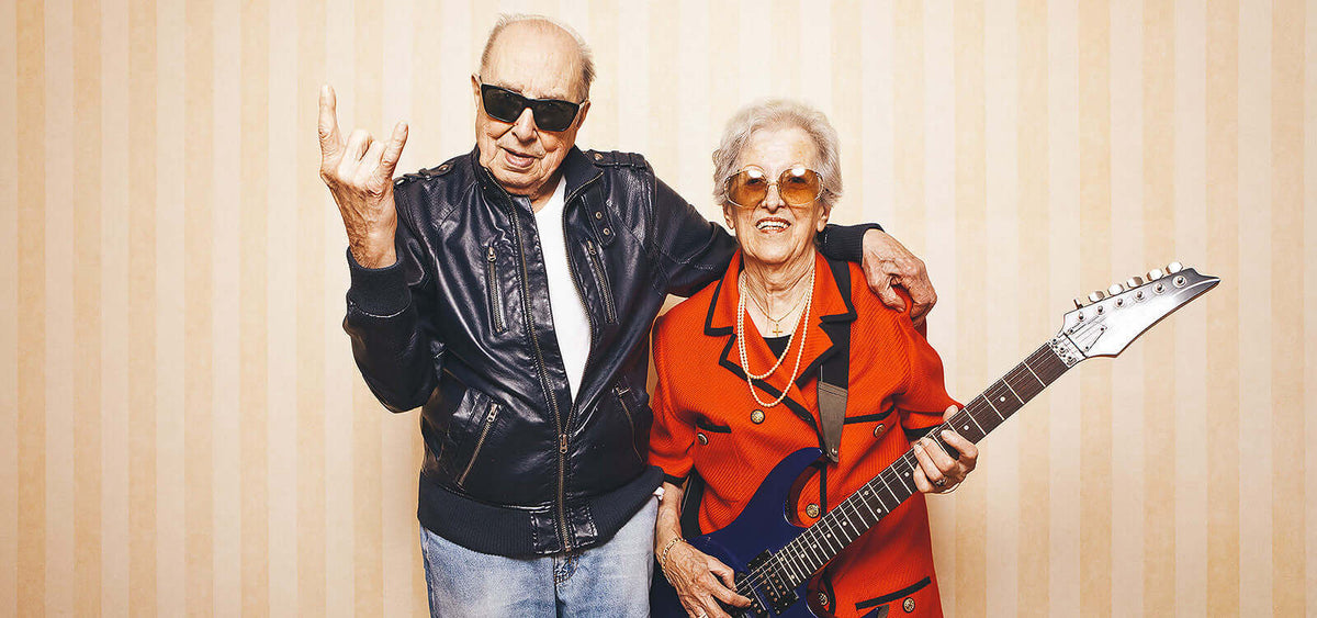elderly couple enjoying life with electric guitar and leather jacket promoting healthy sex life