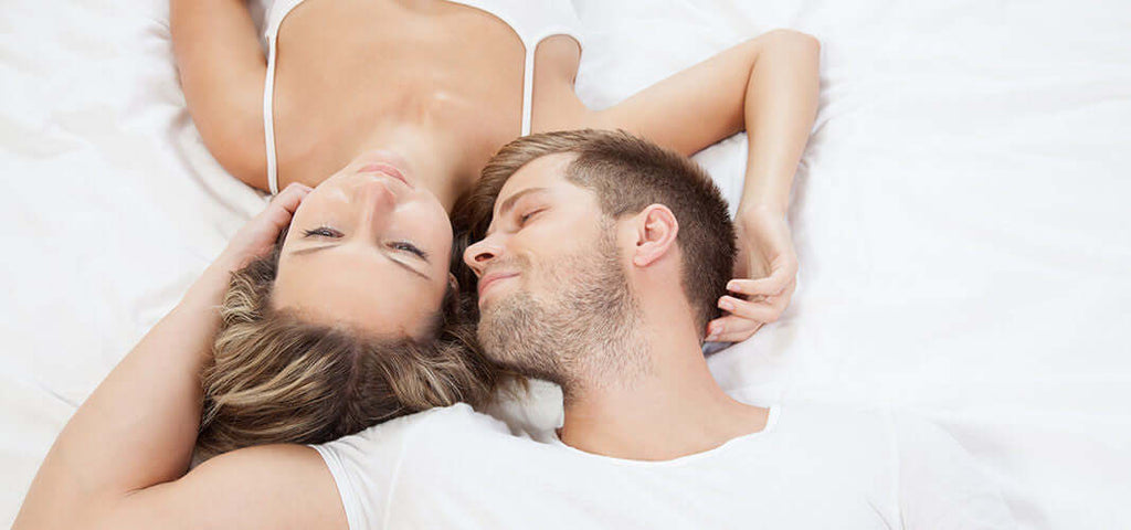 Couple lying in bed enjoying a relaxed and intimate morning moment together