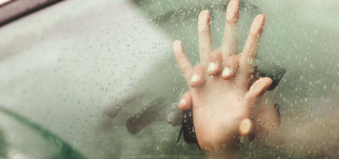 Hands touching on a steamy wet glass surface symbolizing intimacy and connection related to types of lube.