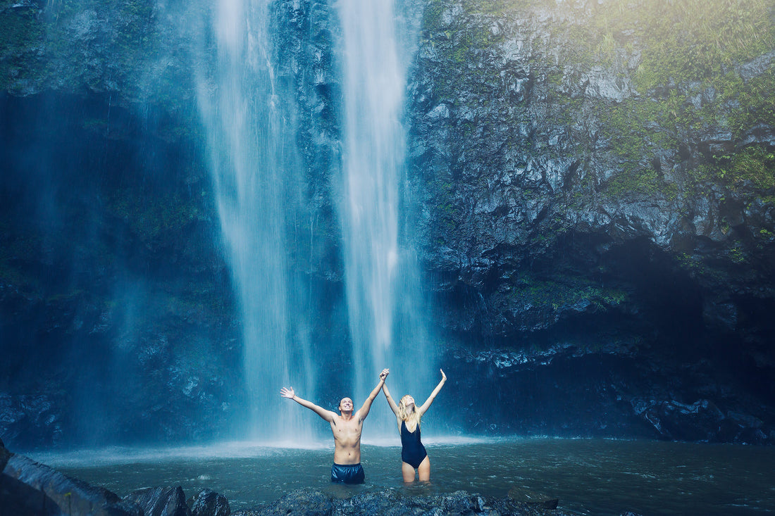 Couple enjoying outdoor sex near a waterfall in a natural setting